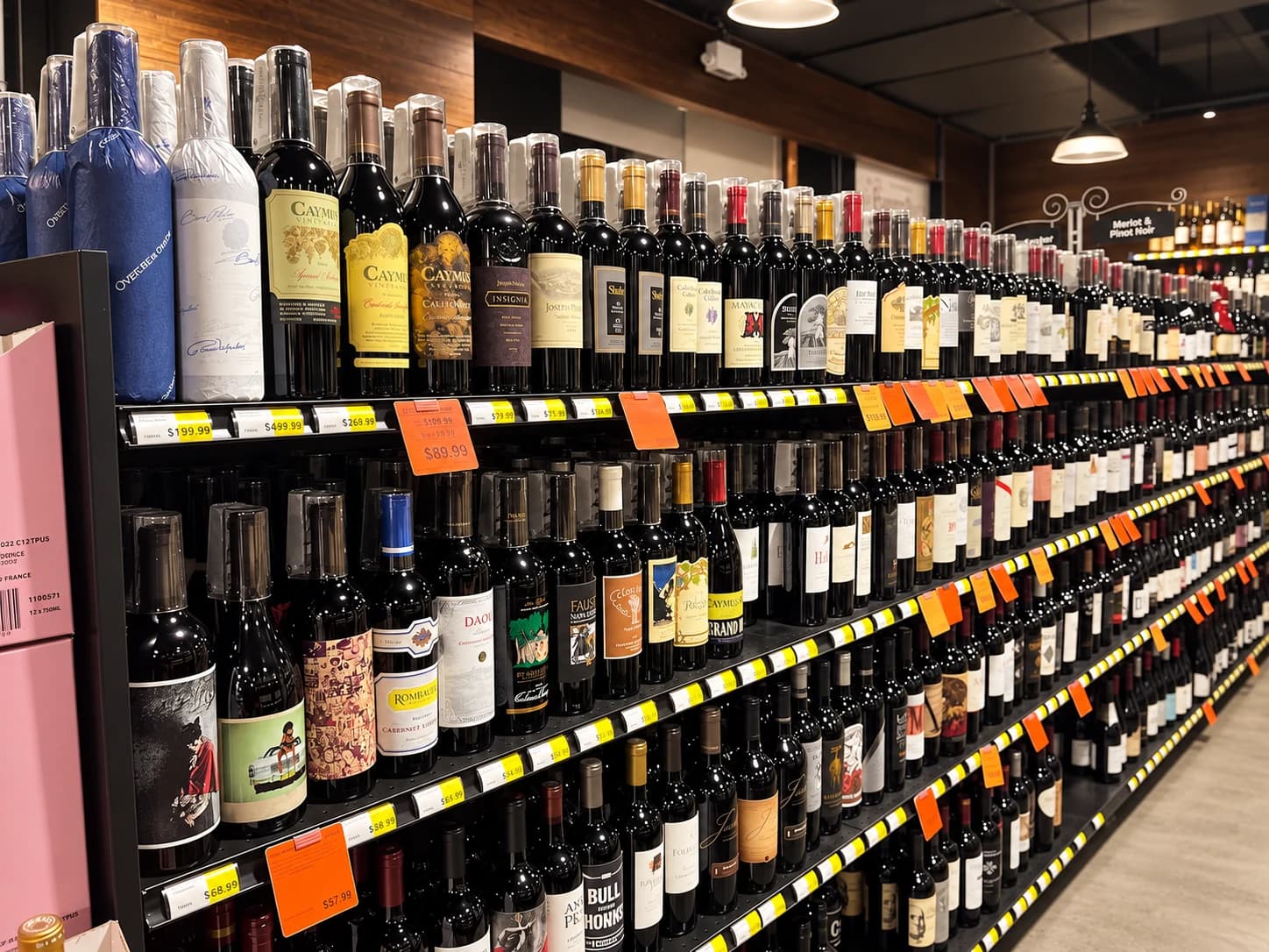 Premium red wines including Caymus and other California producers, arranged along the wine shelves.