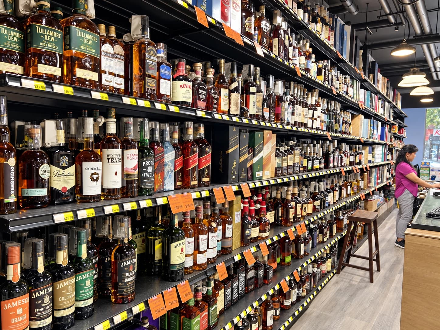 A long selection of Irish whiskey, Scotch and bourbon beside the store counter.